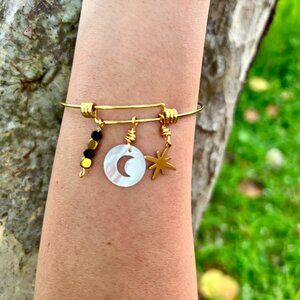 Golden-colored bracelet with a white moon